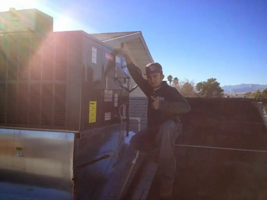 HVAC technician performing Boiler Repair on a rooftop unit in Tea